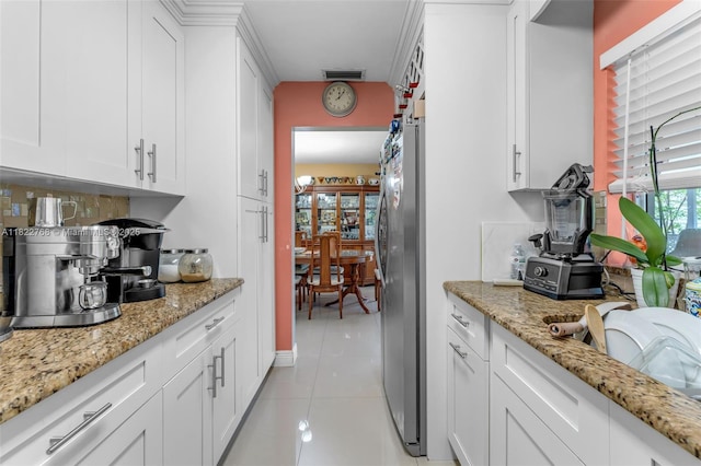 28540 SW 146th Ave, Homestead, FL 33033 - kitchen with freestanding refrigerator, light tile patterned floors, backsplash, and white cabinets