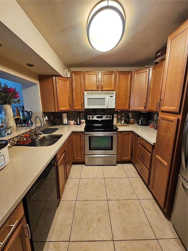 8401 W Sample Rd Unit 10, Coral Springs, FL 33065 - kitchen with stainless steel electric stove, white microwave, black dishwasher, backsplash, and light tile patterned floors