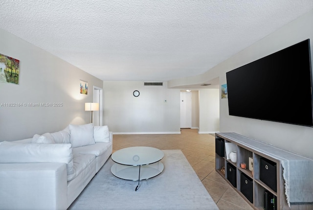 100 Golden Isles Dr Unit 101, Hallandale Beach, FL 33009 - living room featuring light tile patterned floors and a textured ceiling