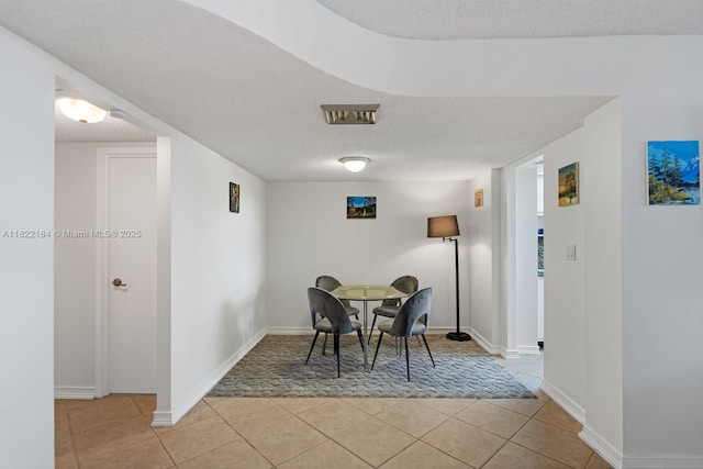 100 Golden Isles Dr Unit 101, Hallandale Beach, FL 33009 - dining space with light tile patterned floors and a textured ceiling