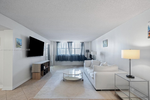 100 Golden Isles Dr Unit 101, Hallandale Beach, FL 33009 - living room featuring a textured ceiling and light tile patterned floors