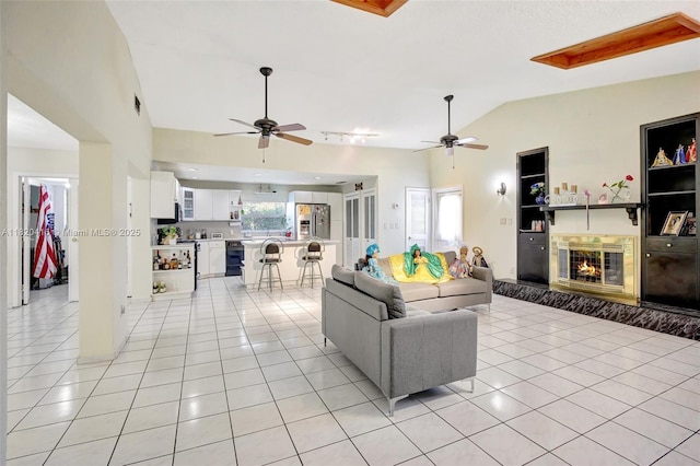 7950 NW 174th Ter, Hialeah, FL 33015 - living room featuring vaulted ceiling, a ceiling fan, light tile patterned floors, and a glass covered fireplace