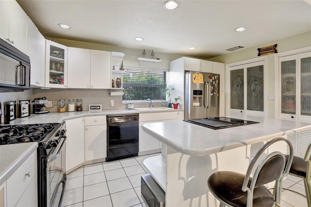 7950 NW 174th Ter, Hialeah, FL 33015 - kitchen with black appliances, light countertops, recessed lighting, light tile patterned floors, and white cabinets