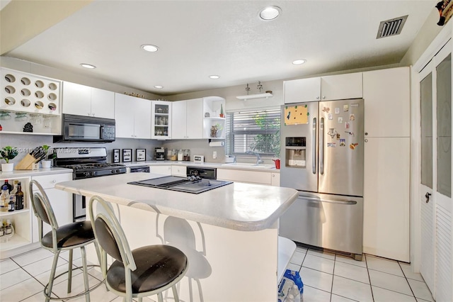 7950 NW 174th Ter, Hialeah, FL 33015 - kitchen featuring appliances with stainless steel finishes, open shelves, light tile patterned floors, a kitchen bar, and light countertops