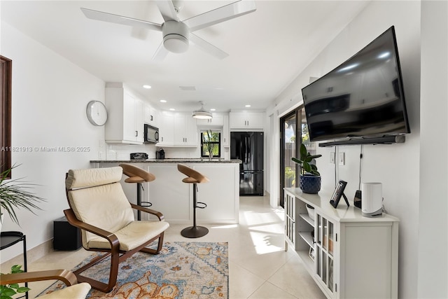 2571 NW 99th Ave, Coral Springs, FL 33065 - kitchen featuring black appliances, a peninsula, dark countertops, white cabinets, and light tile patterned floors