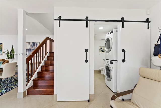 2571 NW 99th Ave, Coral Springs, FL 33065 - laundry room featuring estacked washer and dryer, a barn door, light tile patterned flooring, and recessed lighting