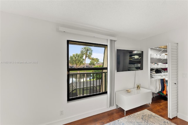 2571 NW 99th Ave, Coral Springs, FL 33065 - bedroom with a walk in closet, wood finished floors, a closet, and a textured ceiling