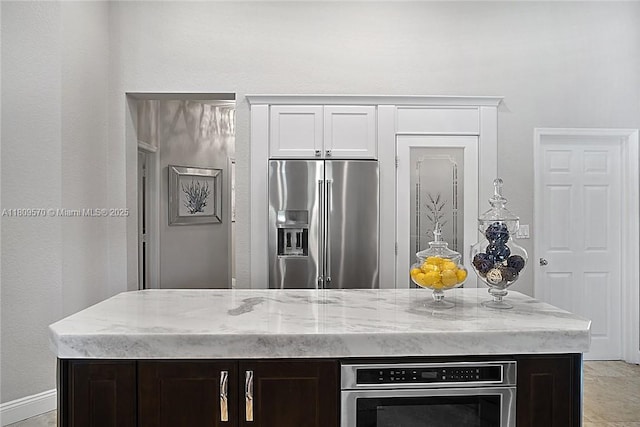 6807 NW 66th Way, Parkland, FL 33067 - kitchen featuring appliances with stainless steel finishes, light stone counters, a kitchen island, and white cabinetry