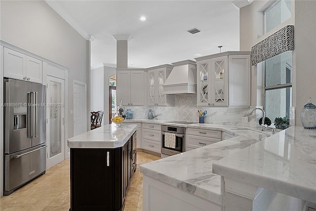 6807 NW 66th Way, Parkland, FL 33067 - kitchen featuring stainless steel appliances, custom range hood, light stone counters, tasteful backsplash, and recessed lighting