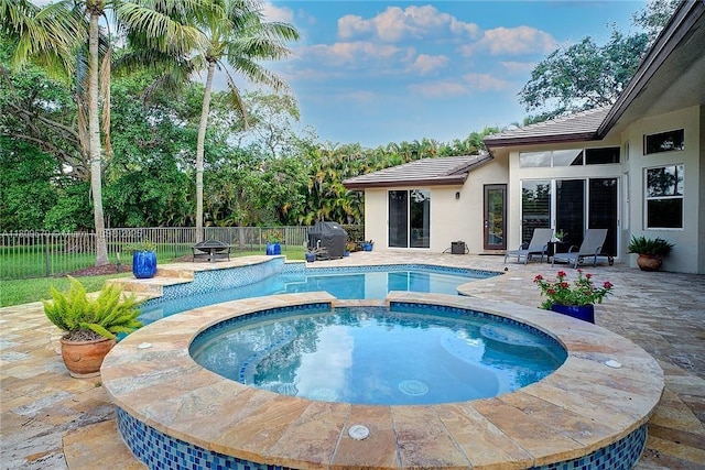 6807 NW 66th Way, Parkland, FL 33067 - view of swimming pool featuring a grill, a patio area, a fenced backyard, and a pool with connected hot tub
