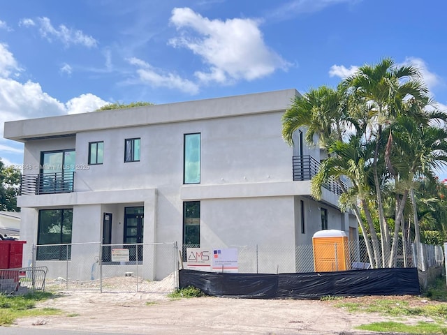 1700 NE 18th St, Fort Lauderdale, FL 33305 - view of front of house featuring a fenced front yard, a balcony, and stucco siding