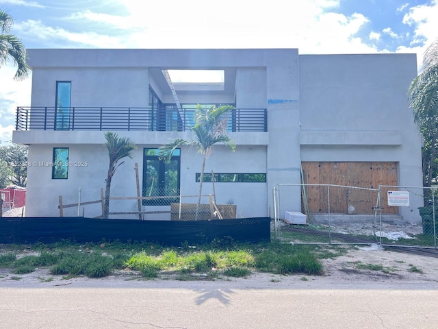 1700 NE 18th St, Fort Lauderdale, FL 33305 - view of front of property featuring a balcony, a fenced front yard, and stucco siding