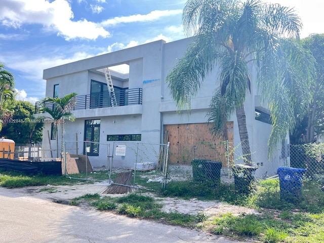 1700 NE 18th St, Fort Lauderdale, FL 33305 - view of front of house featuring a balcony, a gate, a fenced front yard, and stucco siding