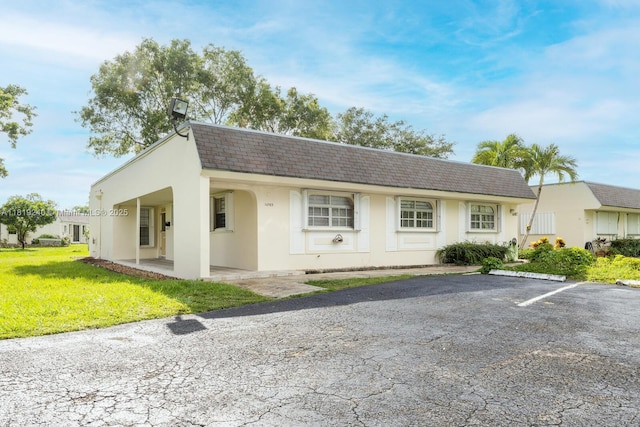 16985 SW 113th Ct Unit 31541E, Miami, FL 33157 - colonial inspired home featuring stucco siding, a front yard, mansard roof, a shingled roof, and uncovered parking
