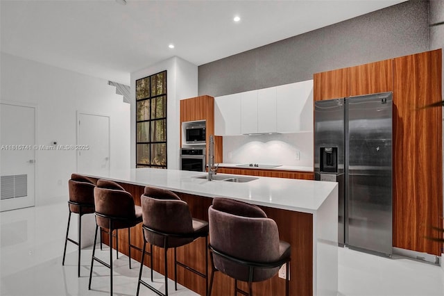 1801 NE 13th St Unit 1823, Fort Lauderdale, FL 33304 - kitchen with appliances with stainless steel finishes, modern cabinets, light countertops, white cabinets, and a kitchen bar