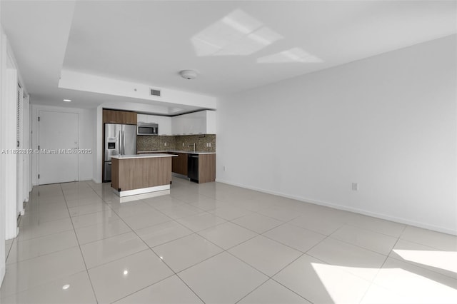5252 NW 85th Ave Unit 1505, Doral, FL 33166 - kitchen with appliances with stainless steel finishes, open floor plan, decorative backsplash, a center island, and light countertops