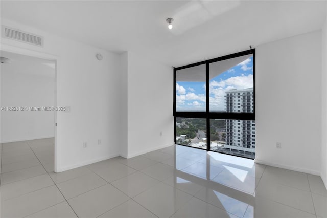 5252 NW 85th Ave Unit 1505, Doral, FL 33166 - empty room with expansive windows, tile patterned flooring, a smoke detector, and a city view