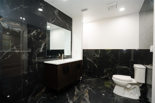 3313 N Ridge Rd, Tallahassee, FL 32305 - bathroom with marble tiled flooring, vanity, a marble finish shower, tile walls, and recessed lighting