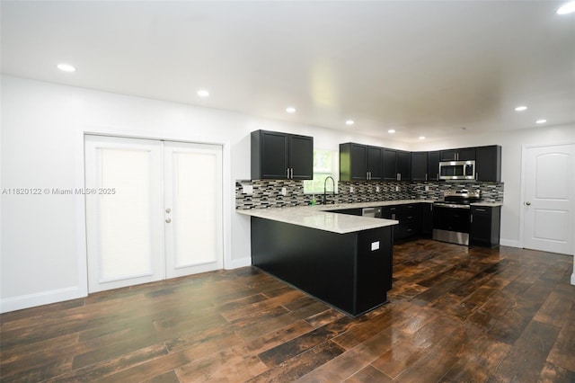 3313 N Ridge Rd, Tallahassee, FL 32305 - kitchen with appliances with stainless steel finishes, a peninsula, light countertops, dark cabinetry, and recessed lighting