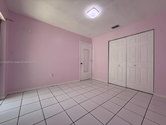 3461 SW 154th Ct, Miami, FL 33185 - unfurnished bedroom featuring a textured ceiling, light tile patterned flooring, and a closet