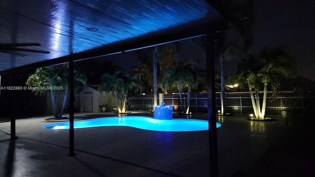 20401 SW 317th St, Homestead, FL 33030 - pool at twilight featuring a storage shed, a fenced backyard, a patio area, and a ceiling fan