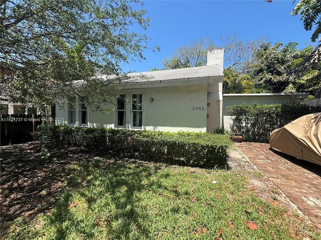 2985 Aviation Ave, Miami, FL 33133 - view of side of property featuring a chimney and stucco siding