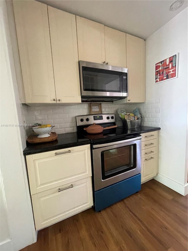 2985 Aviation Ave, Miami, FL 33133 - kitchen featuring appliances with stainless steel finishes, dark countertops, decorative backsplash, and dark wood-style floors