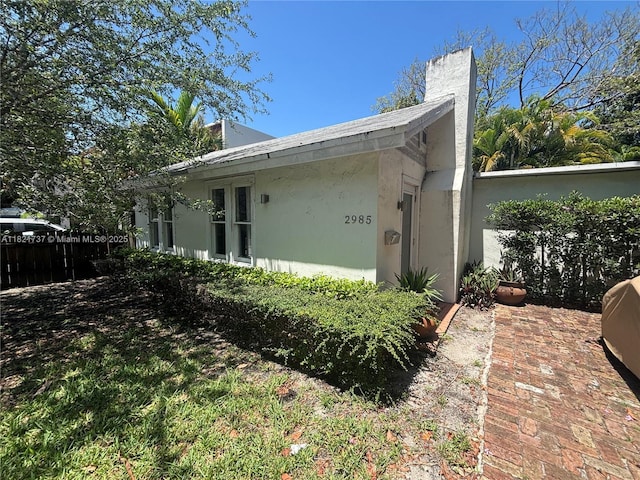 2985 Aviation Ave, Miami, FL 33133 - view of home's exterior featuring stucco siding and a chimney