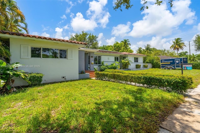 170 NW 105th St, Miami Shores, FL 33150 - mediterranean / spanish home with a front lawn, a tiled roof, and stucco siding