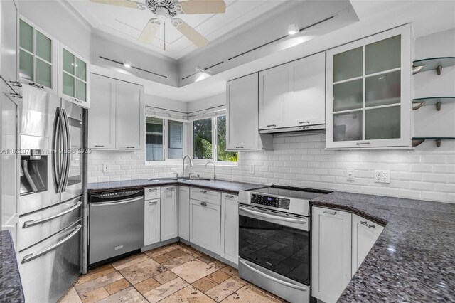 170 NW 105th St, Miami Shores, FL 33150 - kitchen featuring stainless steel appliances, a raised ceiling, decorative backsplash, ceiling fan, and dark stone counters