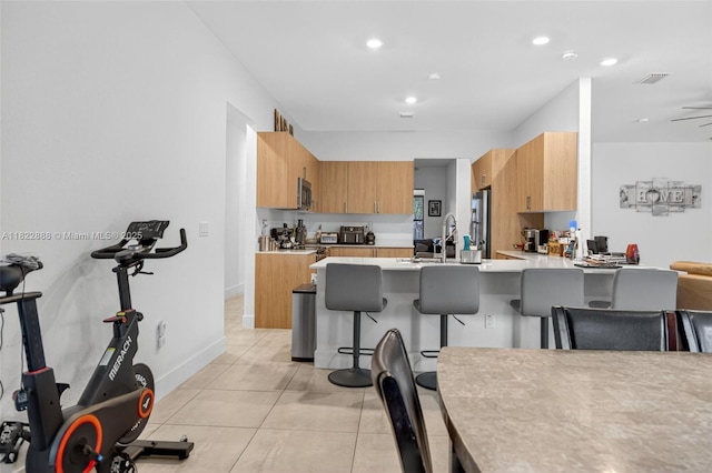 32106 SW 199th Pl, Homestead, FL 33030 - kitchen with stainless steel appliances, a peninsula, a kitchen breakfast bar, light countertops, and light tile patterned floors