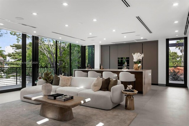 3571 Fair Isle St, Miami, FL 33133 - living room featuring expansive windows, plenty of natural light, finished concrete flooring, and recessed lighting