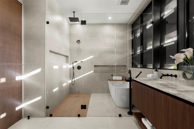 3571 Fair Isle St, Miami, FL 33133 - bathroom featuring a shower stall, a freestanding tub, double vanity, tile walls, and tile patterned flooring