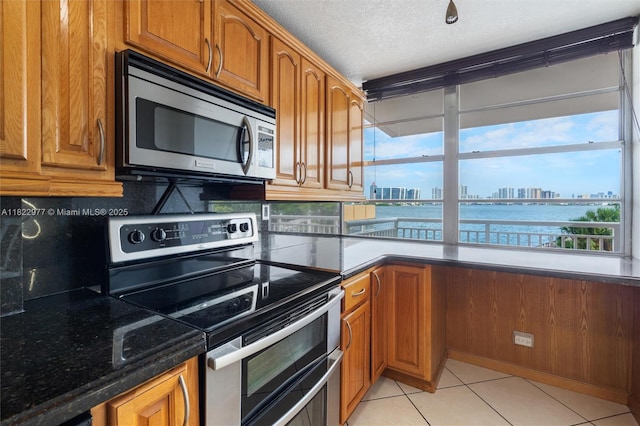 251 174th St Unit 218, Sunny Isles Beach, FL 33160 - kitchen with appliances with stainless steel finishes, brown cabinetry, and a textured ceiling