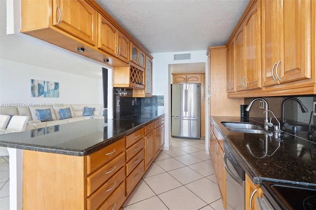 251 174th St Unit 218, Sunny Isles Beach, FL 33160 - kitchen featuring stainless steel appliances, backsplash, dark stone countertops, light tile patterned flooring, and brown cabinetry