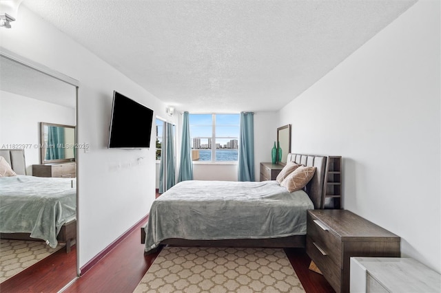 251 174th St Unit 218, Sunny Isles Beach, FL 33160 - bedroom featuring wood finished floors and a textured ceiling