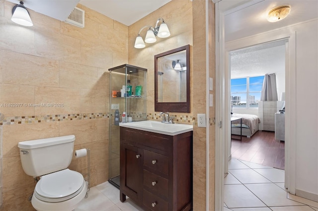 251 174th St Unit 218, Sunny Isles Beach, FL 33160 - bathroom with tile walls, vanity, ensuite bathroom, and tile patterned flooring