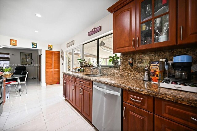 15013 SW 65th Ter, Miami, FL 33193 - kitchen with stainless steel dishwasher, decorative backsplash, dark stone countertops, glass insert cabinets, and light tile patterned floors