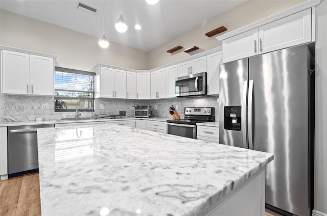 9265 NW 16th St, Pembroke Pines, FL 33024 - kitchen with stainless steel appliances, white cabinets, tasteful backsplash, and hanging light fixtures