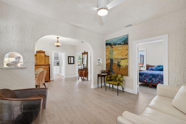 1314 SE 1st Ave, Fort Lauderdale, FL 33316 - living area with a textured wall, arched walkways, light wood-type flooring, a ceiling fan, and a textured ceiling