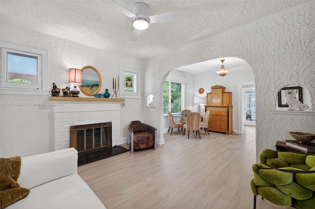 1314 SE 1st Ave, Fort Lauderdale, FL 33316 - living room with arched walkways, a textured wall, a textured ceiling, wood finished floors, and a fireplace