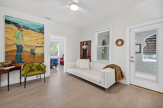 1314 SE 1st Ave, Fort Lauderdale, FL 33316 - living area with light wood-type flooring, a textured wall, a textured ceiling, and a ceiling fan