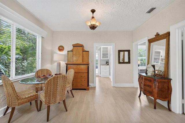 1314 SE 1st Ave, Fort Lauderdale, FL 33316 - dining space with a textured wall, light wood finished floors, healthy amount of natural light, and a textured ceiling