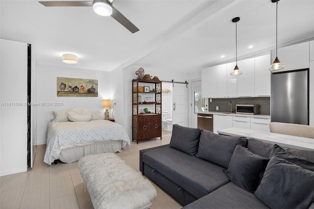 1314 SE 1st Ave, Fort Lauderdale, FL 33316 - bedroom with a barn door, stainless steel fridge, ensuite bathroom, and light tile patterned flooring