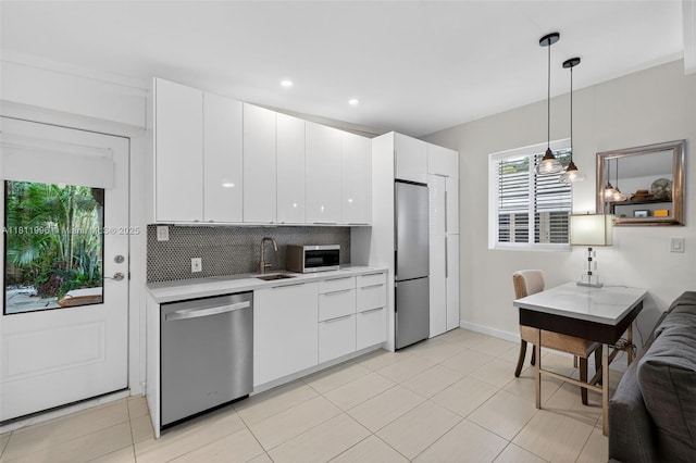 1314 SE 1st Ave, Fort Lauderdale, FL 33316 - kitchen with stainless steel appliances, light countertops, backsplash, white cabinets, and recessed lighting