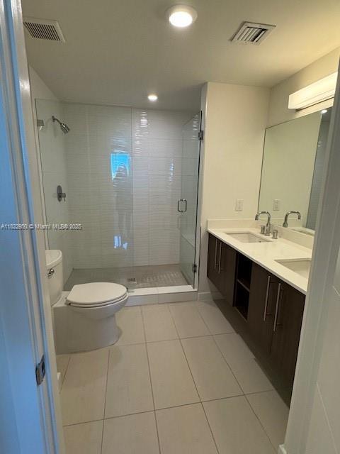7875 NW 107th Ave Unit 410, Doral, FL 33178 - bathroom featuring tile patterned floors, a shower stall, double vanity, and recessed lighting