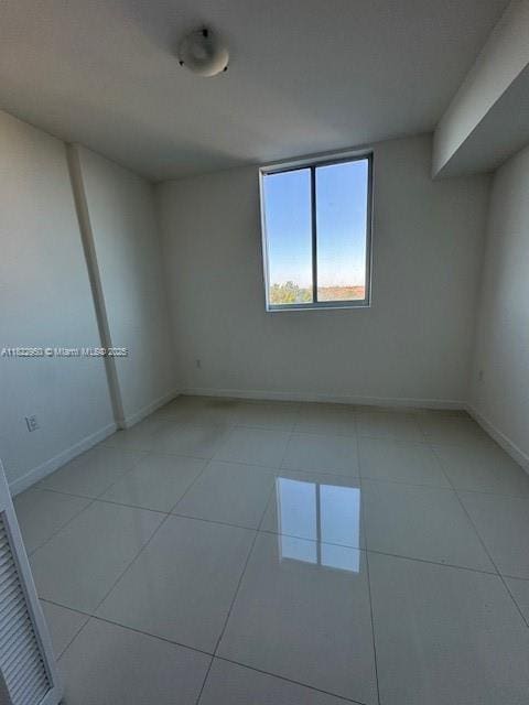 7875 NW 107th Ave Unit 410, Doral, FL 33178 - spare room with light tile patterned floors and baseboards