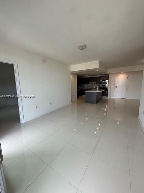 7875 NW 107th Ave Unit 410, Doral, FL 33178 - unfurnished living room featuring light tile patterned floors and a sink