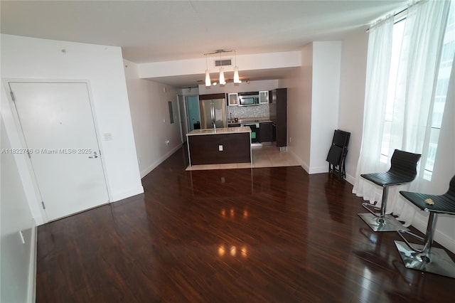 1900 N Bayshore Dr Unit 2510, Miami, FL 33132 - kitchen with stainless steel appliances, backsplash, wood finished floors, a kitchen island, and light countertops