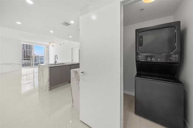 1900 N Bayshore Dr Unit 2104, Miami, FL 33132 - laundry room with stacked washer and clothes dryer, light tile patterned floors, and recessed lighting